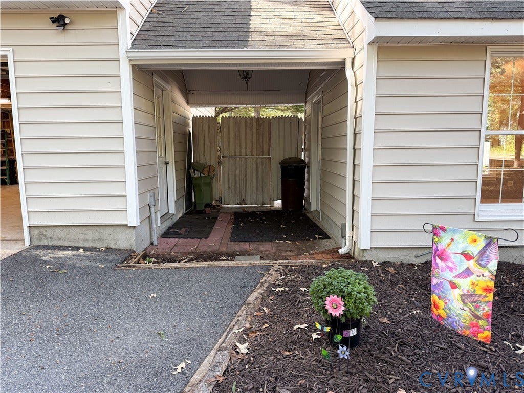 3486 Venter Road, Minors Pines, Aylett, VA 23009 Covered entryway featuring horizontal vinyl siding, a brick-paver threshold, and a full-height privacy fence