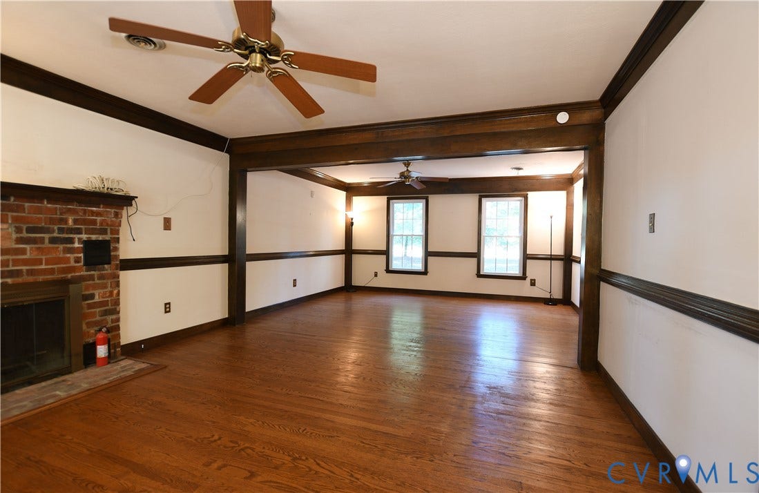 3486 Venter Road, Minors Pines, Aylett, VA 23009 Hardwood flooring, brick fireplace, dark-stained crown molding and chair rail trim, and dual ceiling fans