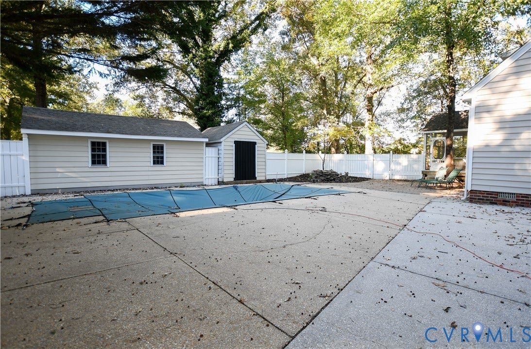 3486 Venter Road, Minors Pines, Aylett, VA 23009 Backyard featuring a concrete pool deck, fenced perimeter, detached storage structure, and siding exterior