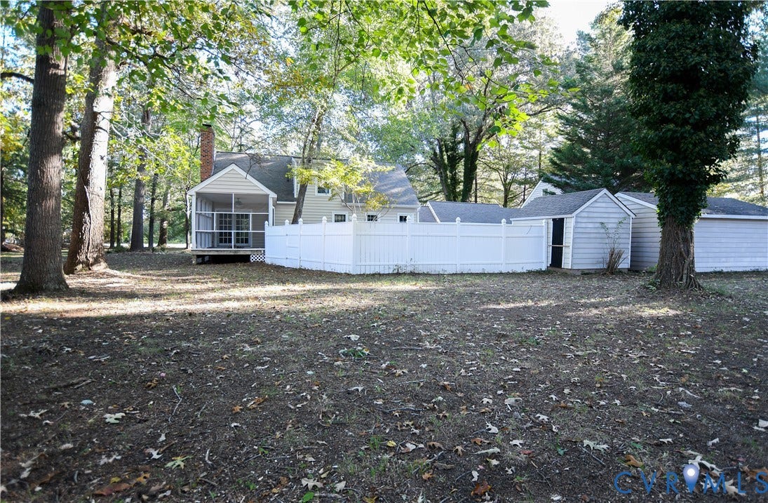 3486 Venter Road, Minors Pines, Aylett, VA 23009 Large private backyard featuring mature trees, white vinyl privacy fencing, a screened porch, and detached storage structures