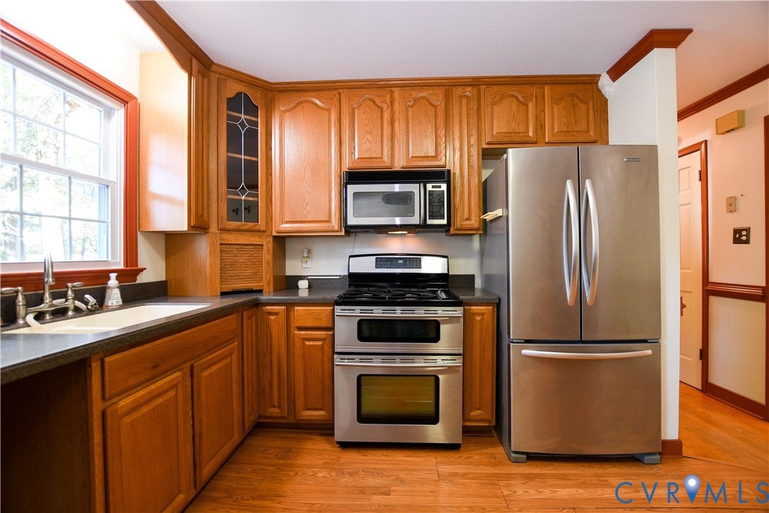 3486 Venter Road, Minors Pines, Aylett, VA 23009 Kitchen featuring oak cabinetry with integrated glass-paneled display shelving, stainless steel appliances, a double-oven range, and wood-finish flooring