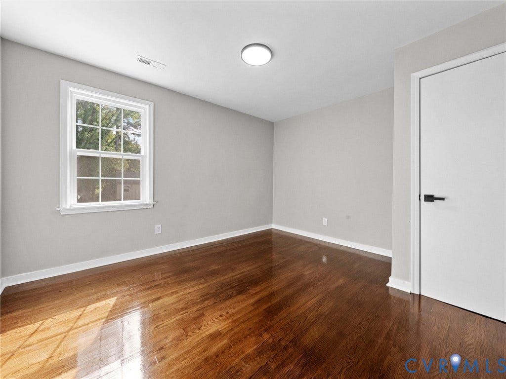 1811 Murdoch Road, Henrico, VA 23229 Refinished wood-finish flooring, neutral wall tones, multi-pane window with custom trim, and modern interior door with matte black hardware