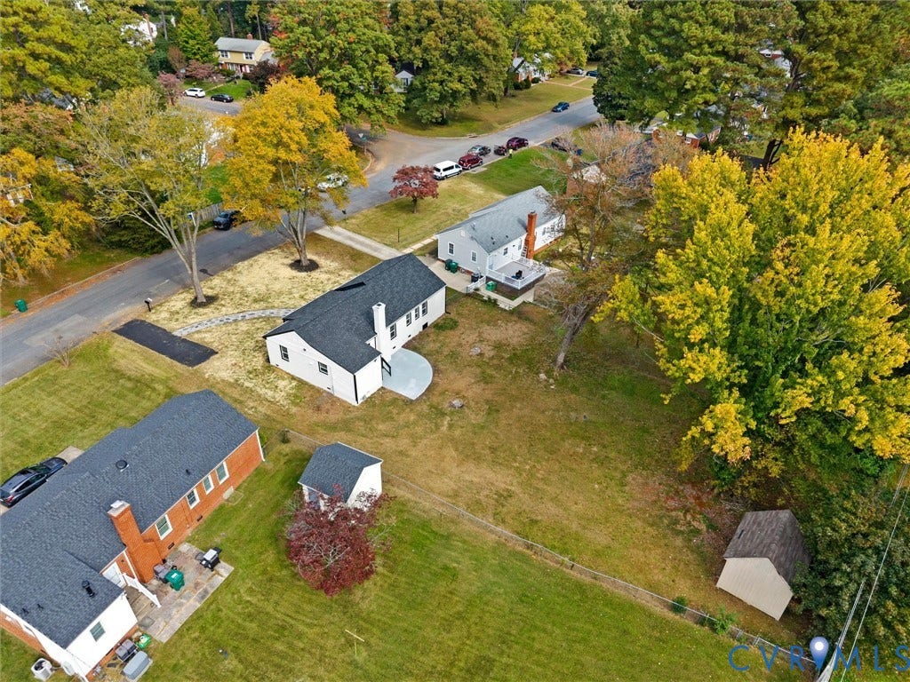 1811 Murdoch Road, Henrico, VA 23229 Aerial perspective of a property featuring a sprawling lot, mature trees, a detached storage structure, a stone-paved walkway, and a rear circular patio