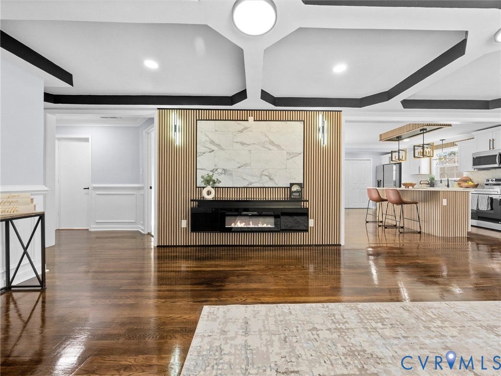 1811 Murdoch Road, Henrico, VA 23229 Coffered ceiling with contrasting trim, wood-slat accent wall, wall-mounted electric fireplace, stone-finish fireplace surround, and wood-finish flooring