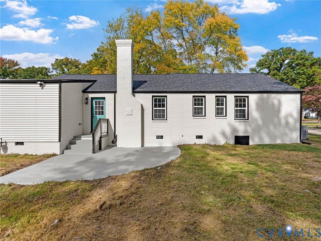 1811 Murdoch Road, Henrico, VA 23229 Exterior featuring painted brick siding, a prominent central masonry chimney, concrete patio, and a shingled roof