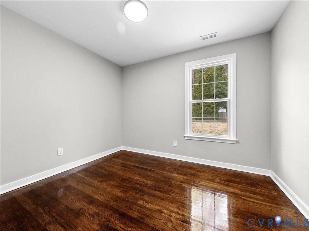 1811 Murdoch Road, Henrico, VA 23229 Interior space featuring wood-finish flooring, a double-hung window with casing, and a flush-mount ceiling light fixture