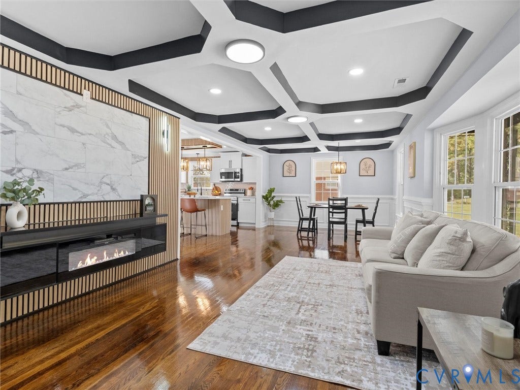 1811 Murdoch Road, Henrico, VA 23229 Coffered ceiling with dark accent trim, wood-finish flooring, custom slatted wood wall feature, integrated electric fireplace with stone-look surround, and recessed lighting
