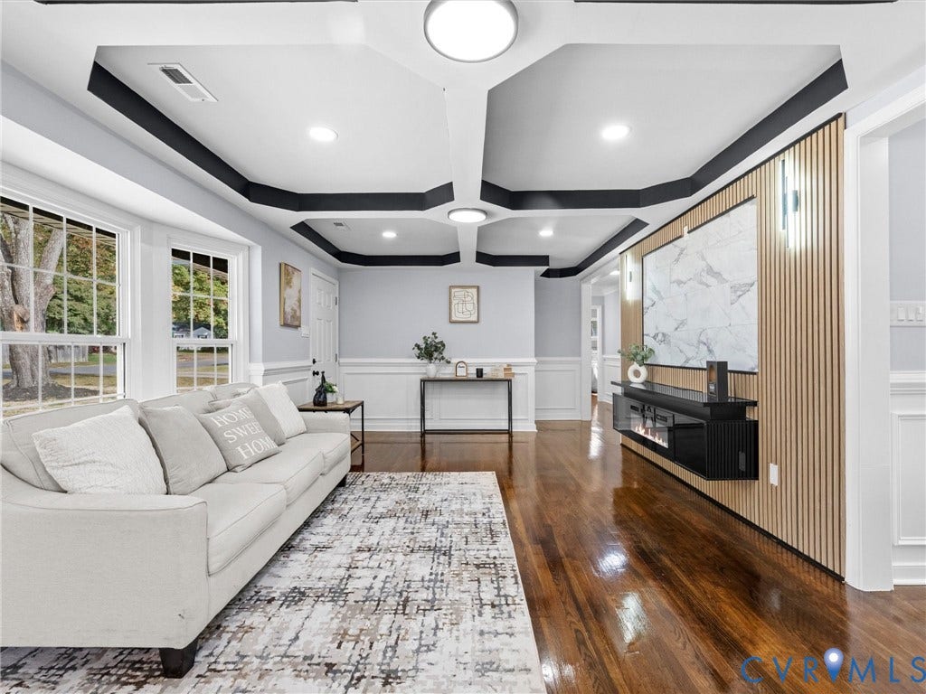 1811 Murdoch Road, Henrico, VA 23229 Coffered ceiling with dark accent trim, wood-finish flooring, and a floor-to-ceiling slatted wood accent wall featuring a stone-patterned panel and a mounted electric fireplace