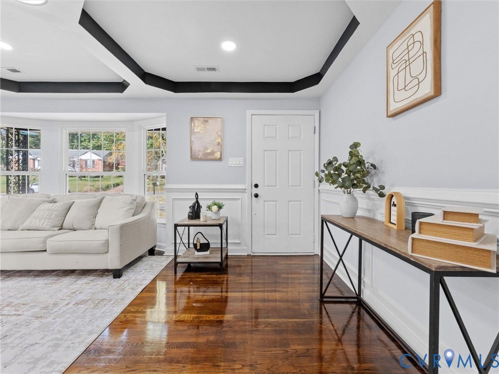 1811 Murdoch Road, Henrico, VA 23229 Tray ceiling with dark accent molding, bay window, wood-finish flooring, and white wainscoting