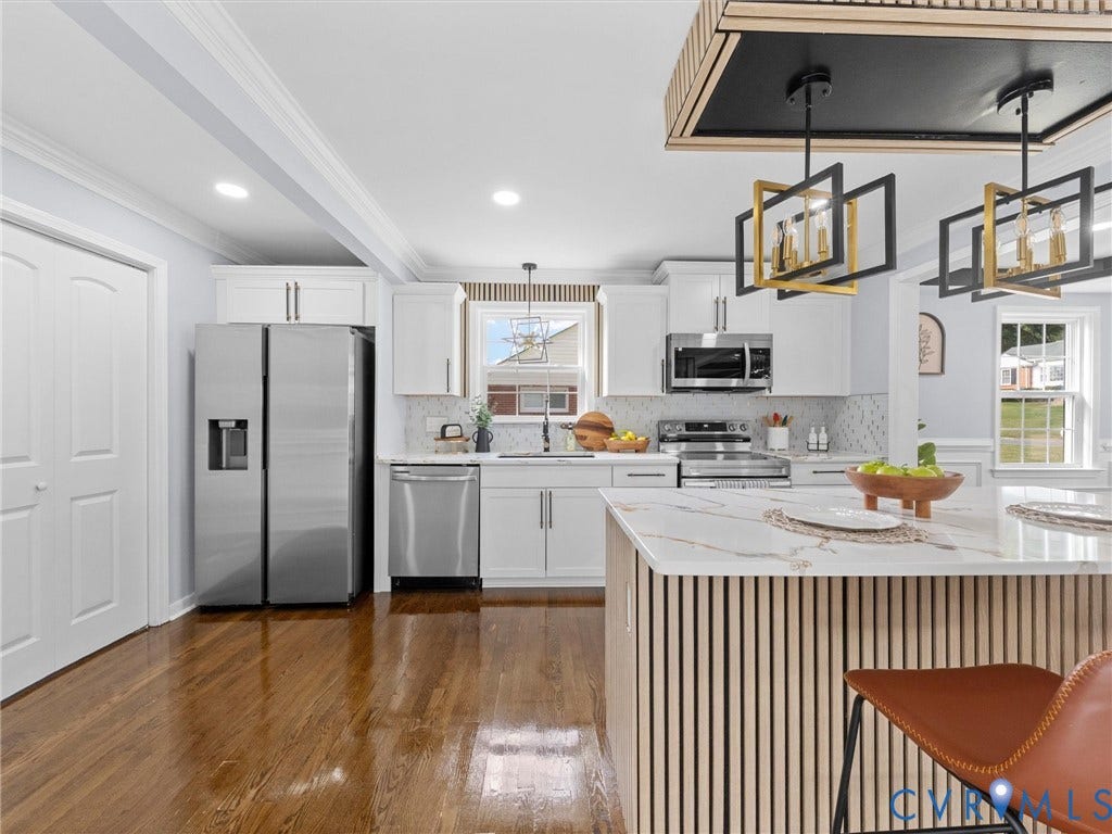 1811 Murdoch Road, Henrico, VA 23229 Kitchen featuring white shaker-style cabinetry, stainless steel appliances, wood-finish flooring, a kitchen island with a slatted wood-finish base, and geometric pendant lighting