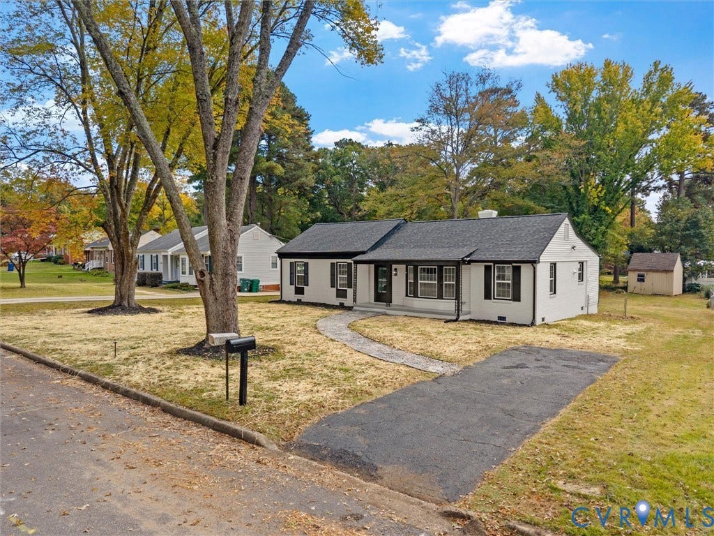 1811 Murdoch Road, Henrico, VA 23229 Single-story exterior featuring painted brick siding, black shutter accents, a shingled roof, a paved walkway, and a detached storage structure