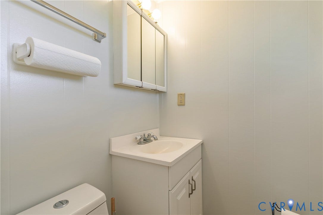 20311 McKenney Highway, Dinwiddie, VA 23882 Wall-mounted vanity cabinet with an integrated sink, dual-door mirrored medicine cabinet, and brushed metal faucet hardware