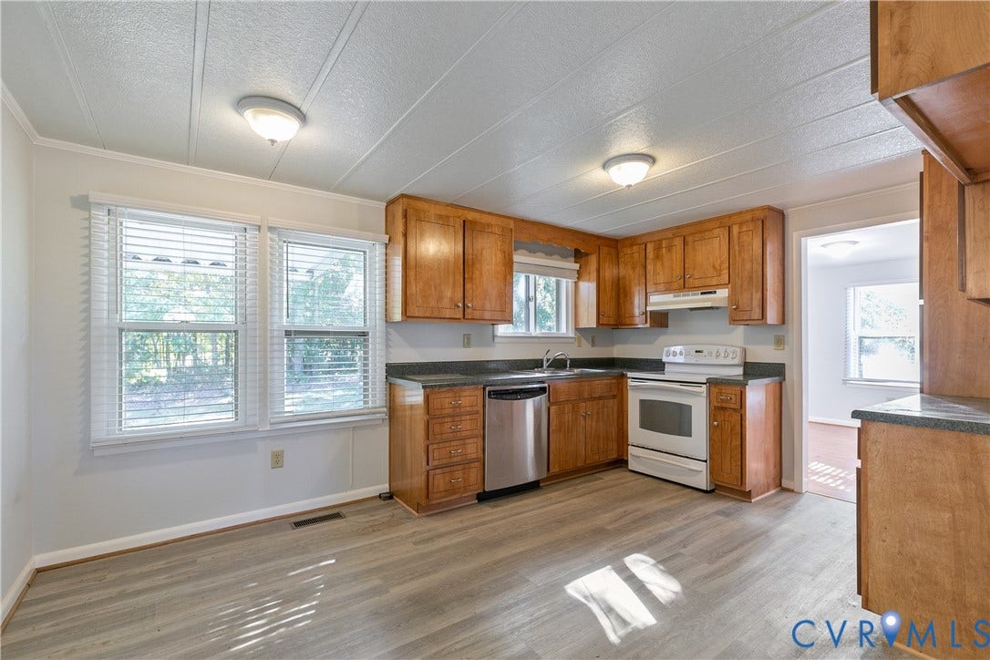 20311 McKenney Highway, Dinwiddie, VA 23882 Kitchen featuring wood-finish cabinetry, dark solid-surface countertops, stainless steel dishwasher, white range, and wood-finish flooring