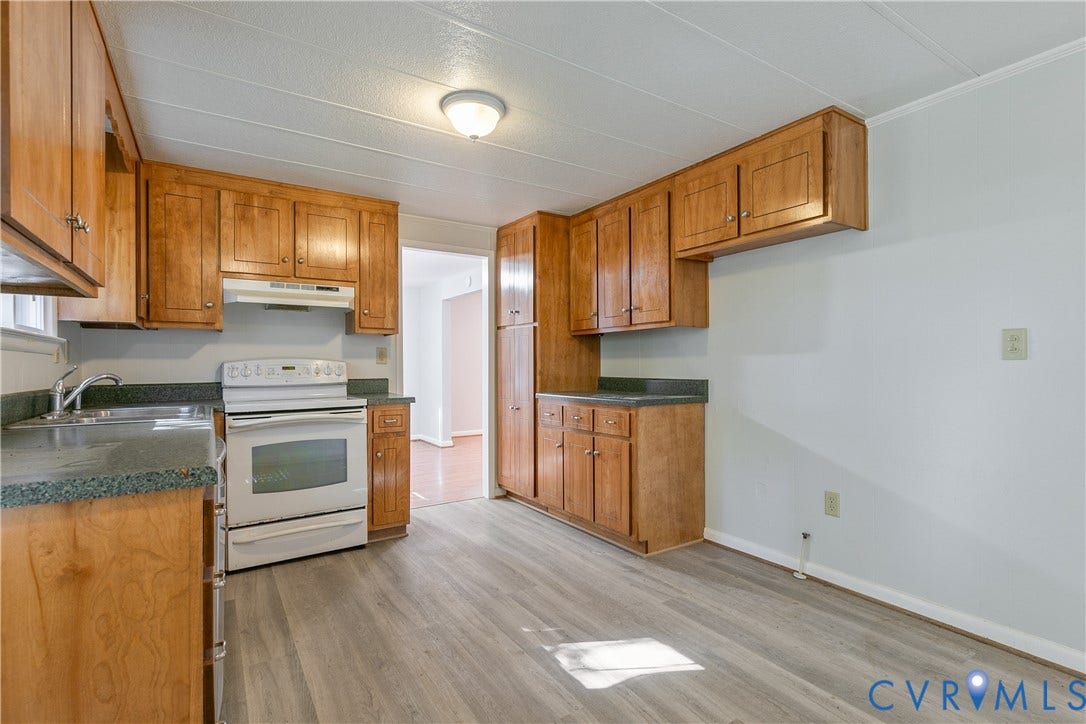 20311 McKenney Highway, Dinwiddie, VA 23882 Kitchen featuring wood cabinetry, solid-surface countertops, wood-finish flooring, white range, and a ceiling-mounted light fixture