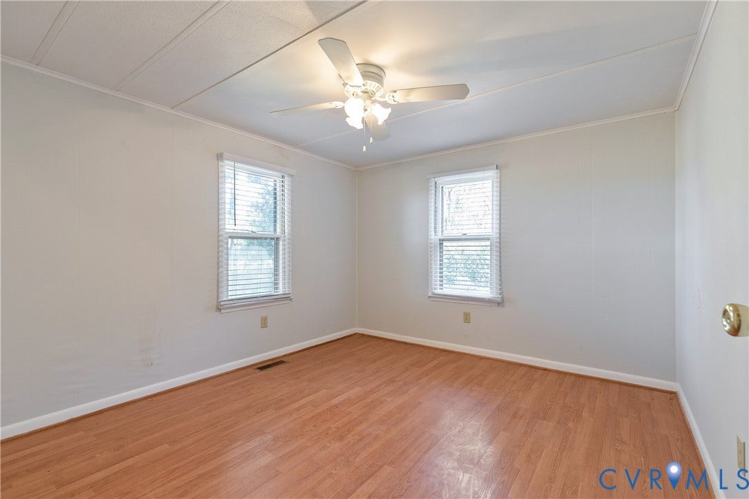 20311 McKenney Highway, Dinwiddie, VA 23882 Room featuring wood-finish flooring, dual windows with blinds, and a central ceiling fan with integrated lighting