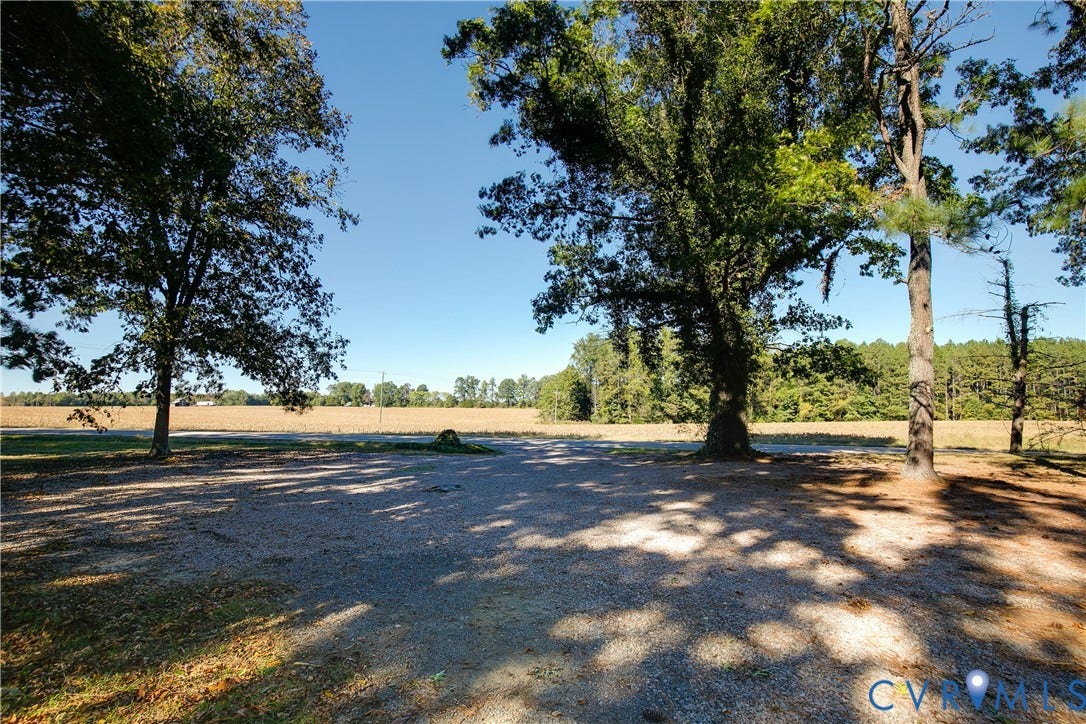 20311 McKenney Highway, Dinwiddie, VA 23882 Expansive cleared lot featuring gravel ground cover, mature hardwood trees, and open terrain