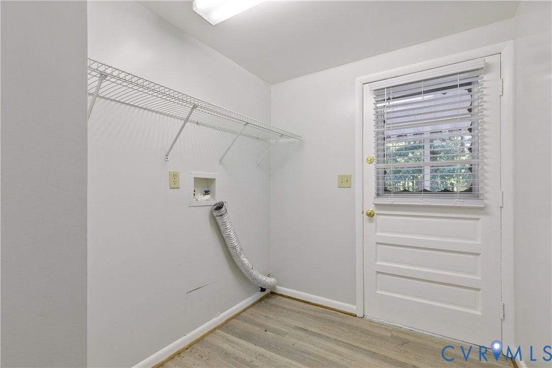 20311 McKenney Highway, Dinwiddie, VA 23882 Utility area featuring wood-finish flooring, white wall-mounted shelving, and an exterior door with an integrated window
