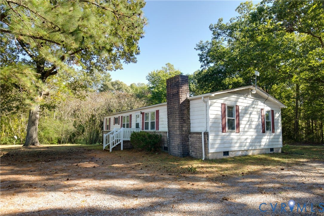 20311 McKenney Highway, Dinwiddie, VA 23882 Single-story residence featuring white siding, red shutters, a brick chimney, and a raised wooden entryway