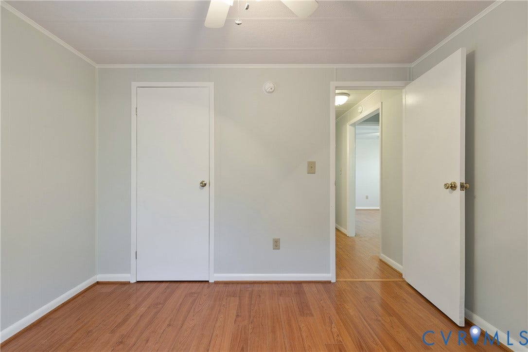 20311 McKenney Highway, Dinwiddie, VA 23882 Neutral-toned interior space featuring wood-finish flooring, solid-core doors, and a ceiling-mounted fan