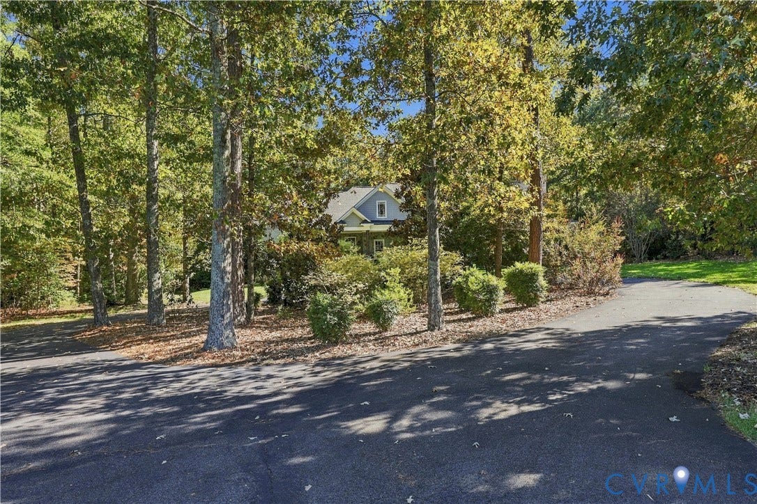 3056 Greywalls Drive, Powhatan, VA 23139 Asphalt driveway leading to a residence surrounded by mature trees and landscaped shrubbery