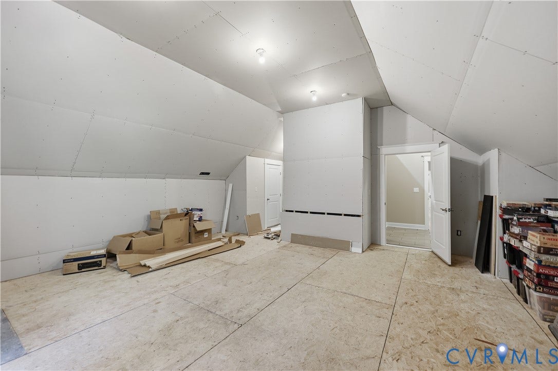 3056 Greywalls Drive, Powhatan, VA 23139 Unfinished space featuring vaulted ceilings, drywall-ready surfaces, plywood subflooring, and two interior doors