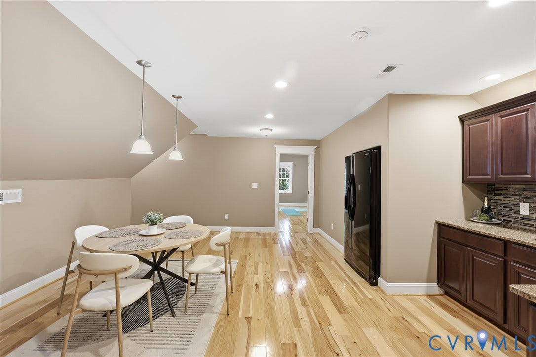 3056 Greywalls Drive, Powhatan, VA 23139 Wood-finish flooring, recessed lighting, dual pendant fixtures, dark-stained cabinetry, and a stacked stone backsplash