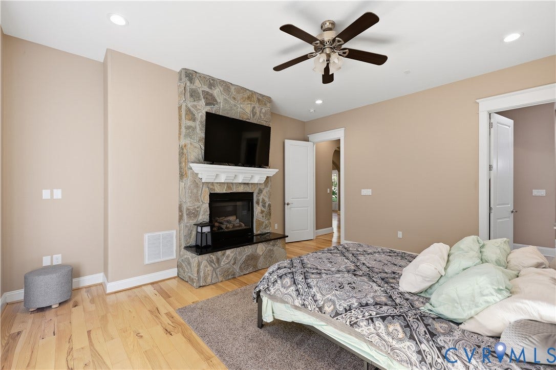 3056 Greywalls Drive, Powhatan, VA 23139 Primary Bedroom 2. Fireplace featuring floor-to-ceiling stone surround, decorative white mantle, and hearth with polished dark stone top