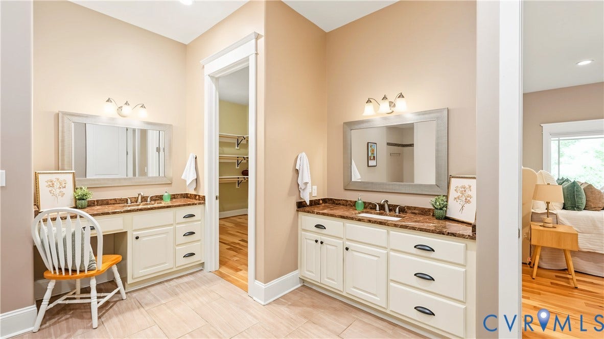 3056 Greywalls Drive, Powhatan, VA 23139 Dual vanity area featuring white cabinetry, stone-finish countertops, framed wall mirrors, and integrated vanity seating