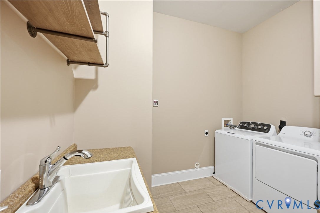 3056 Greywalls Drive, Powhatan, VA 23139 1st Floor Laundry area featuring tile flooring, a drop-in utility sink with stone-finish countertop, polished chrome faucet, and industrial-style pipe-supported shelving