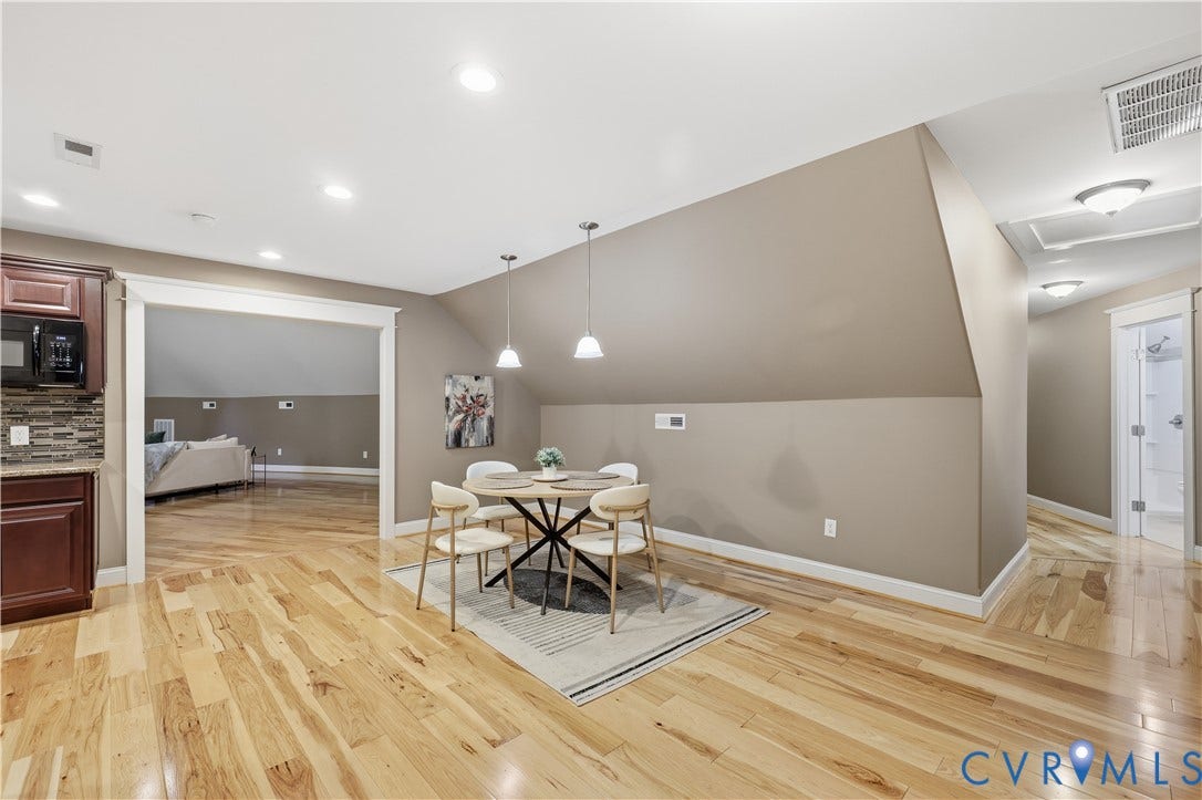 3056 Greywalls Drive, Powhatan, VA 23139 Open floor plan featuring wood-finish flooring, recessed lighting, dual pendant light fixtures, and a vaulted ceiling