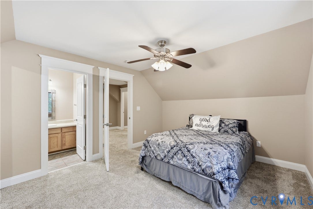 3056 Greywalls Drive, Powhatan, VA 23139 Upstairs Bedroom. Neutral-toned bedroom featuring vaulted ceilings, wall-to-wall carpeting, and a multi-blade ceiling fan with integrated lighting