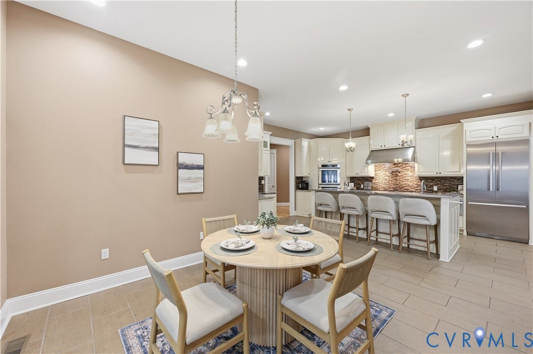 3056 Greywalls Drive, Powhatan, VA 23139 Kitchen featuring custom cabinetry, stainless steel appliances, tiled backsplash, center island with breakfast bar seating, and ceramic tile flooring
