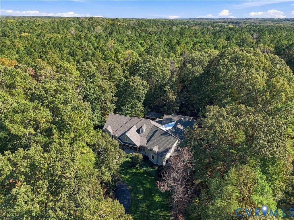 3056 Greywalls Drive, Powhatan, VA 23139 Aerial perspective featuring a multi-gabled roofline, sprawling woodland lot, and extensive mature tree canopy