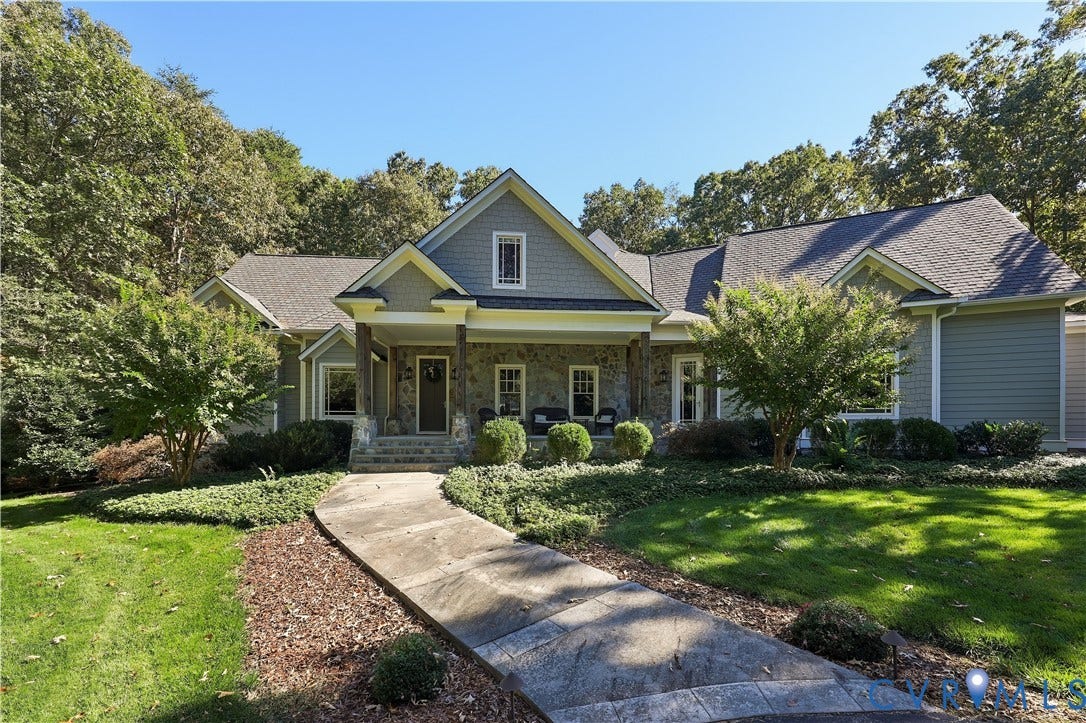 3056 Greywalls Drive, Powhatan, VA 23139 Craftsman-style exterior featuring stone veneer, shingle-pattern siding, covered porch, and a stamped concrete walkway surrounded by mature landscaping