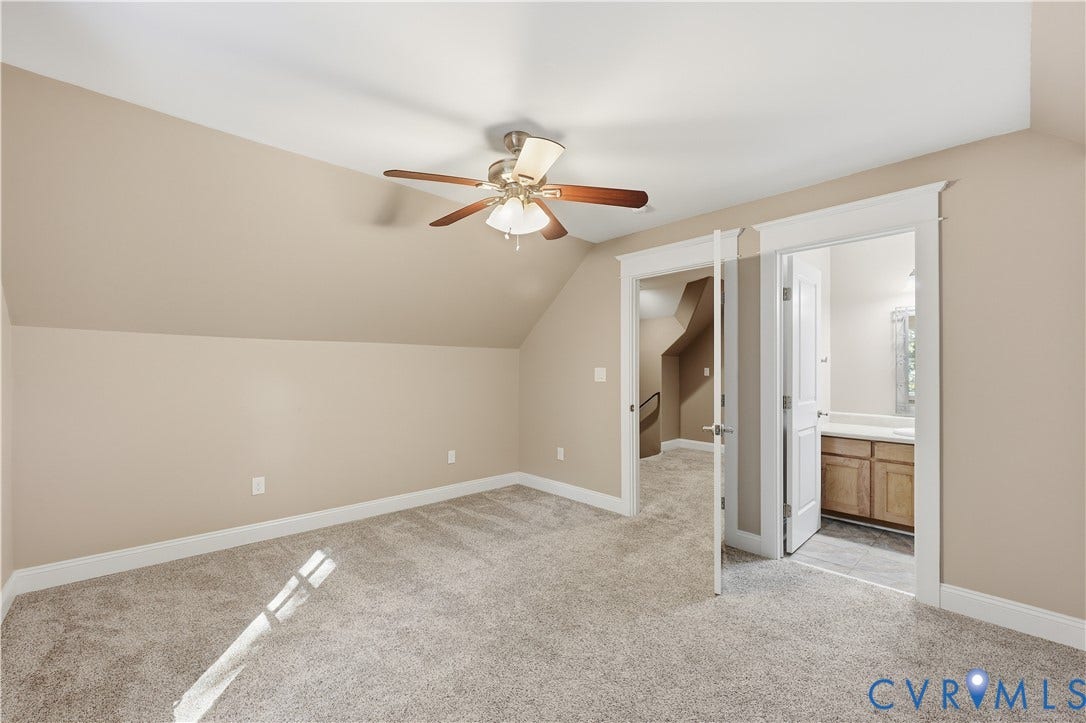 3056 Greywalls Drive, Powhatan, VA 23139 Upstairs Bedroom. Neutral-toned bedroom featuring slanted ceilings, wall-to-wall carpeting, and a multi-blade ceiling fan with a central light fixture