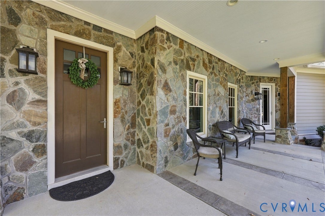 3056 Greywalls Drive, Powhatan, VA 23139 Covered entryway featuring irregular-patterned stone exterior, solid wood entry door, multiple double-hung windows, and recessed lighting