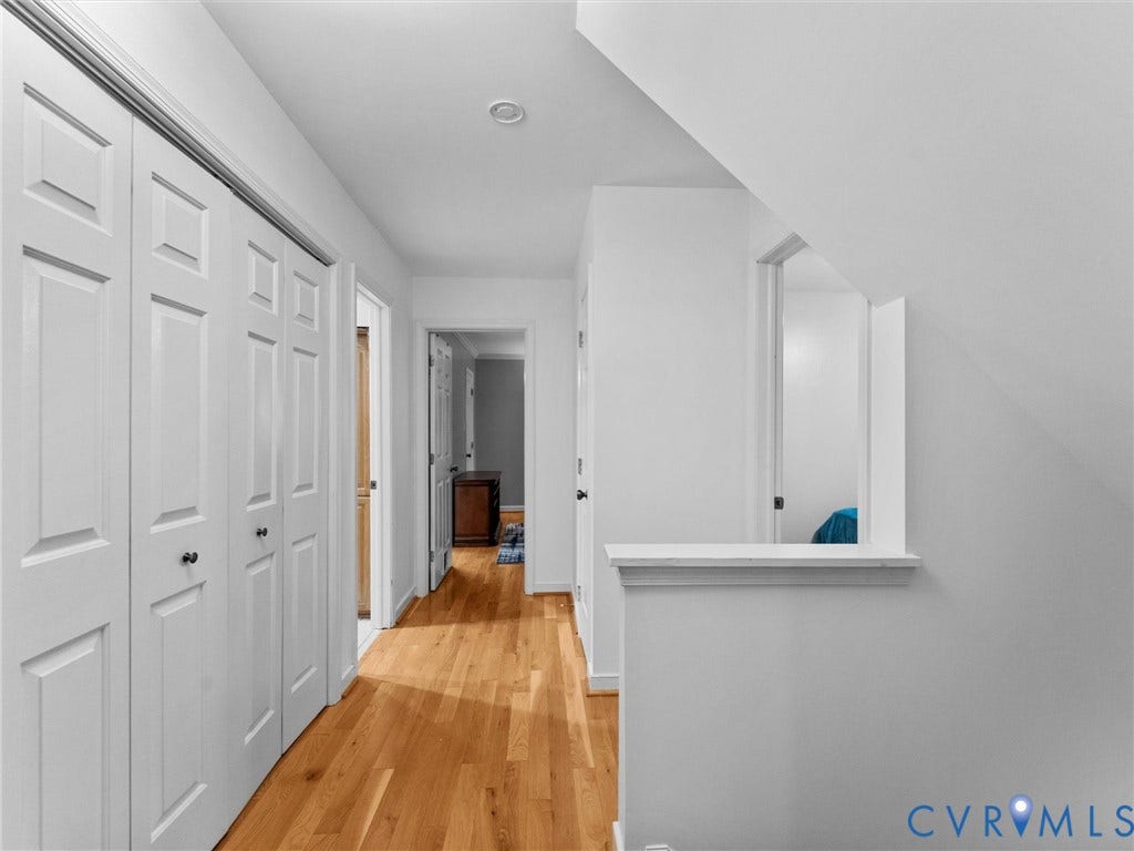 Hallway featuring wood-finish flooring, white paneled bi-fold closet doors, recessed lighting, and a partial knee wall
