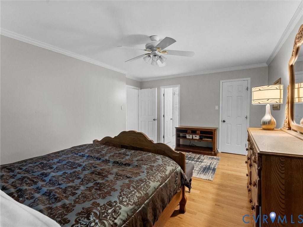 Room featuring wood-finish flooring, crown molding, and a ceiling fan with integrated lighting