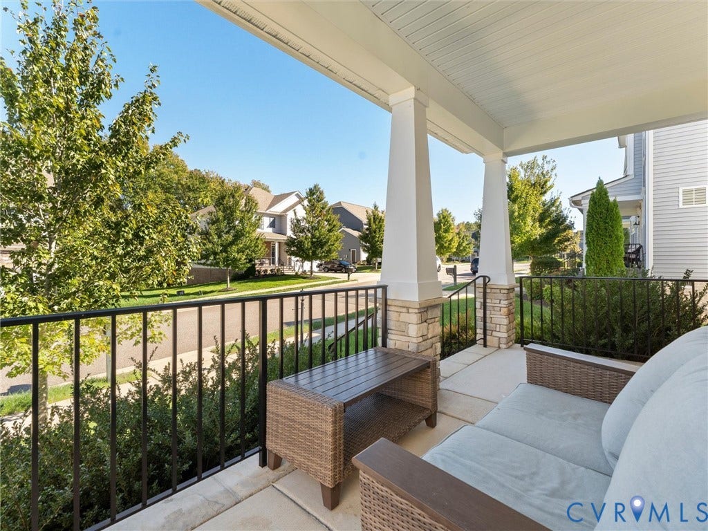 5726 Gossamer Place, Wynwood At FoxCreek, Moseley, VA 23120 Covered front porch featuring tapered columns with stone-veneer bases, metal railings, and a concrete floor