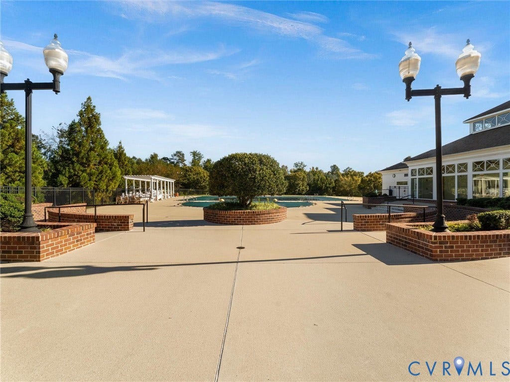 5726 Gossamer Place, Wynwood At FoxCreek, Moseley, VA 23120 Concrete pool deck featuring brick-encased planters, dual-head iron lamp posts, and a covered pavilion