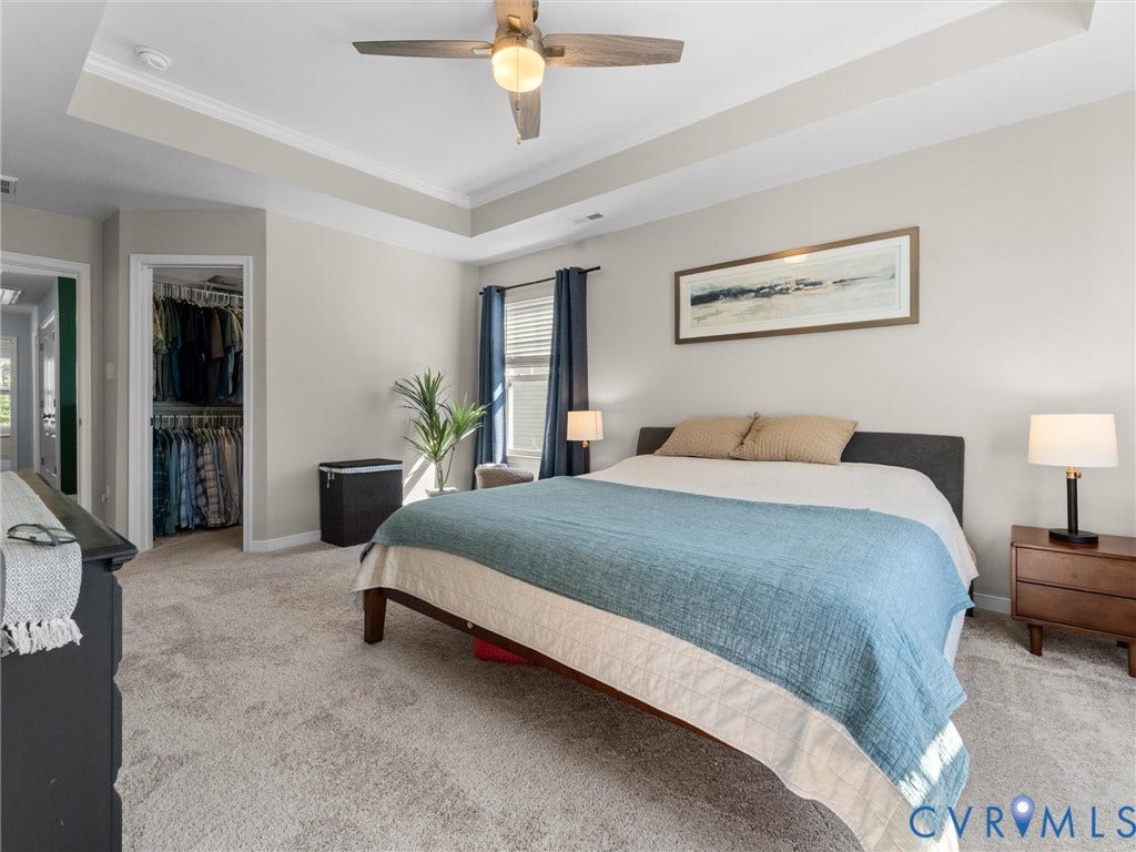 5726 Gossamer Place, Wynwood At FoxCreek, Moseley, VA 23120 Neutral-toned room featuring a tray ceiling, wall-to-wall carpeting, and a walk-in closet with built-in shelving