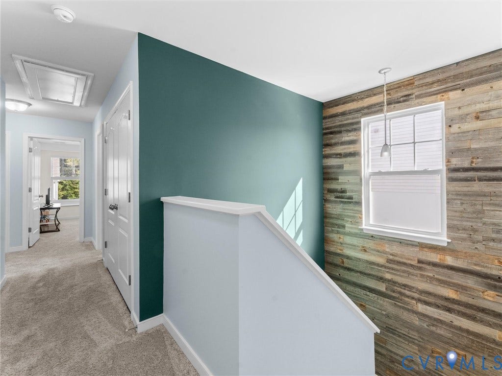 5726 Gossamer Place, Wynwood At FoxCreek, Moseley, VA 23120 Hallway featuring an accent wall with wood-finish paneling, a secondary deep-toned accent wall, and a single-light pendant fixture