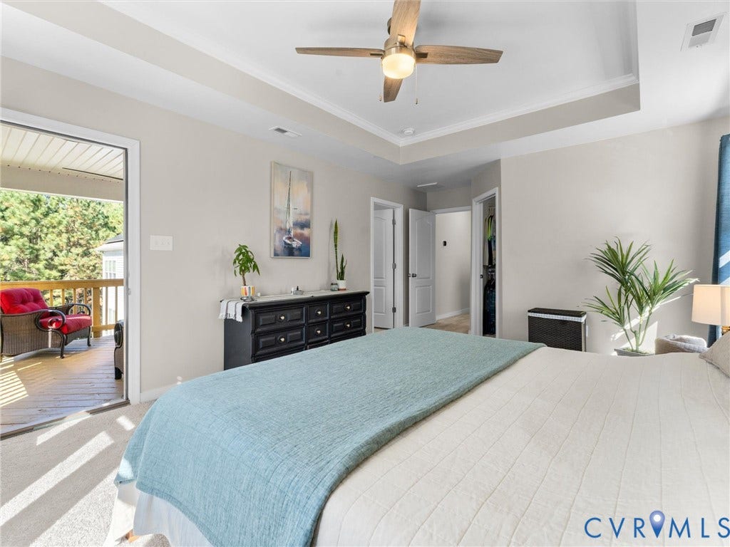 5726 Gossamer Place, Wynwood At FoxCreek, Moseley, VA 23120 Tray ceiling featuring a central ceiling fan, neutral wall color, and glass-paned door opening to a wooden deck