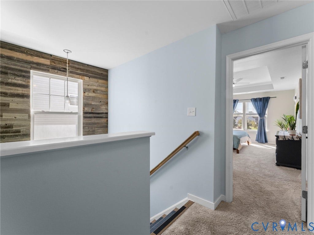 5726 Gossamer Place, Wynwood At FoxCreek, Moseley, VA 23120 Wall featuring horizontal wood-plank cladding, single-hung window, pendant lighting, and a wooden handrail with metal supports