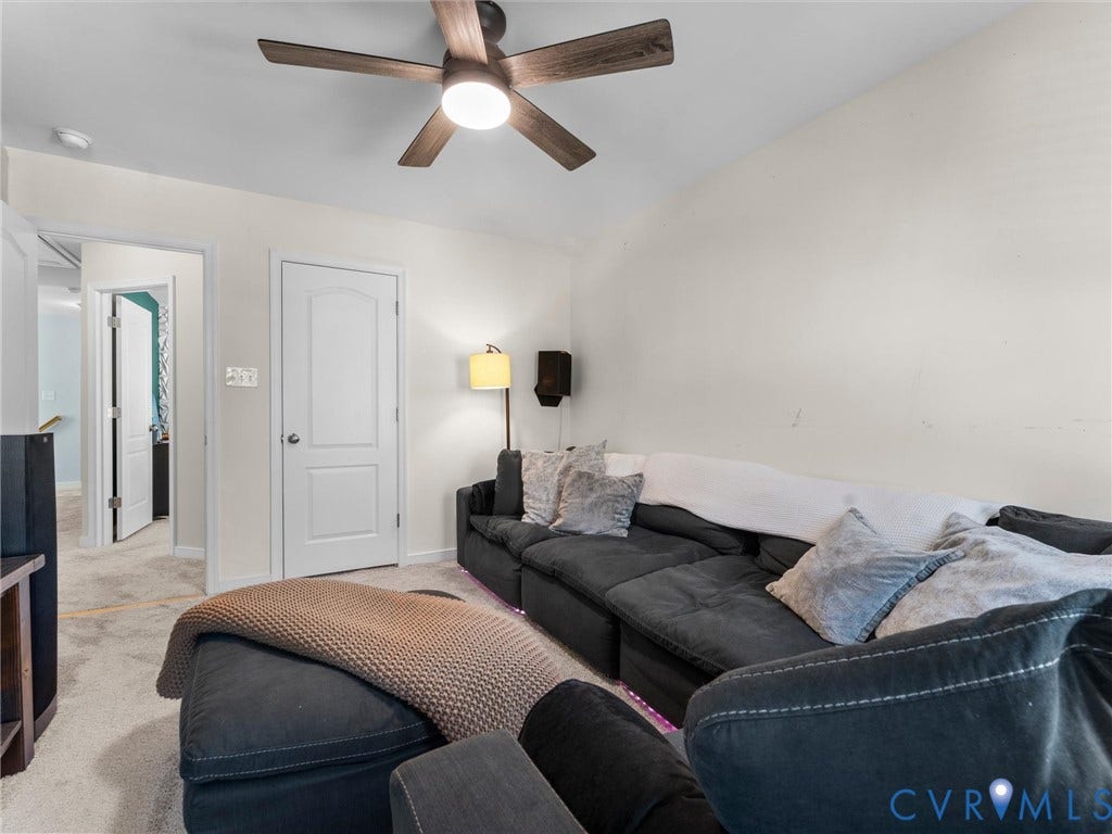 5726 Gossamer Place, Wynwood At FoxCreek, Moseley, VA 23120 Interior space featuring wall-to-wall carpeting, an arched-panel interior door, and a central ceiling fan with integrated lighting