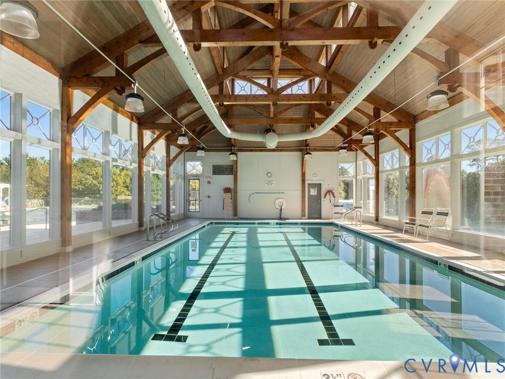 5726 Gossamer Place, Wynwood At FoxCreek, Moseley, VA 23120 Indoor pool facility featuring exposed timber truss vaulted ceilings, floor-to-ceiling windows, and recessed perimeter lighting