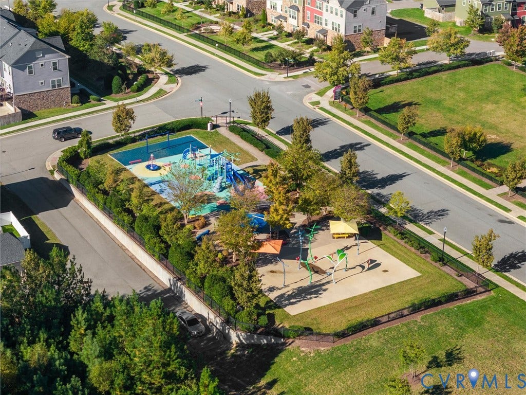 5726 Gossamer Place, Wynwood At FoxCreek, Moseley, VA 23120 Community recreation area featuring a paved playground, water play elements, shade structures, and mature trees enclosed by perimeter fencing