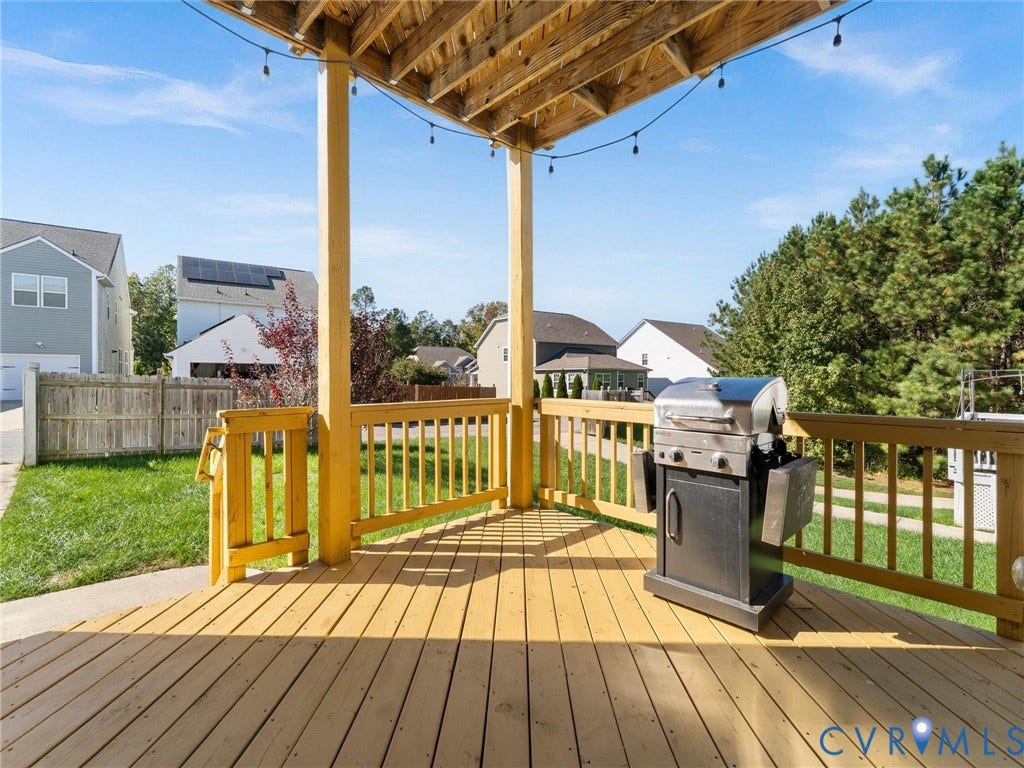 5726 Gossamer Place, Wynwood At FoxCreek, Moseley, VA 23120 Covered wooden deck featuring natural wood-finish railings, overhead structural beams, and a concrete patio section