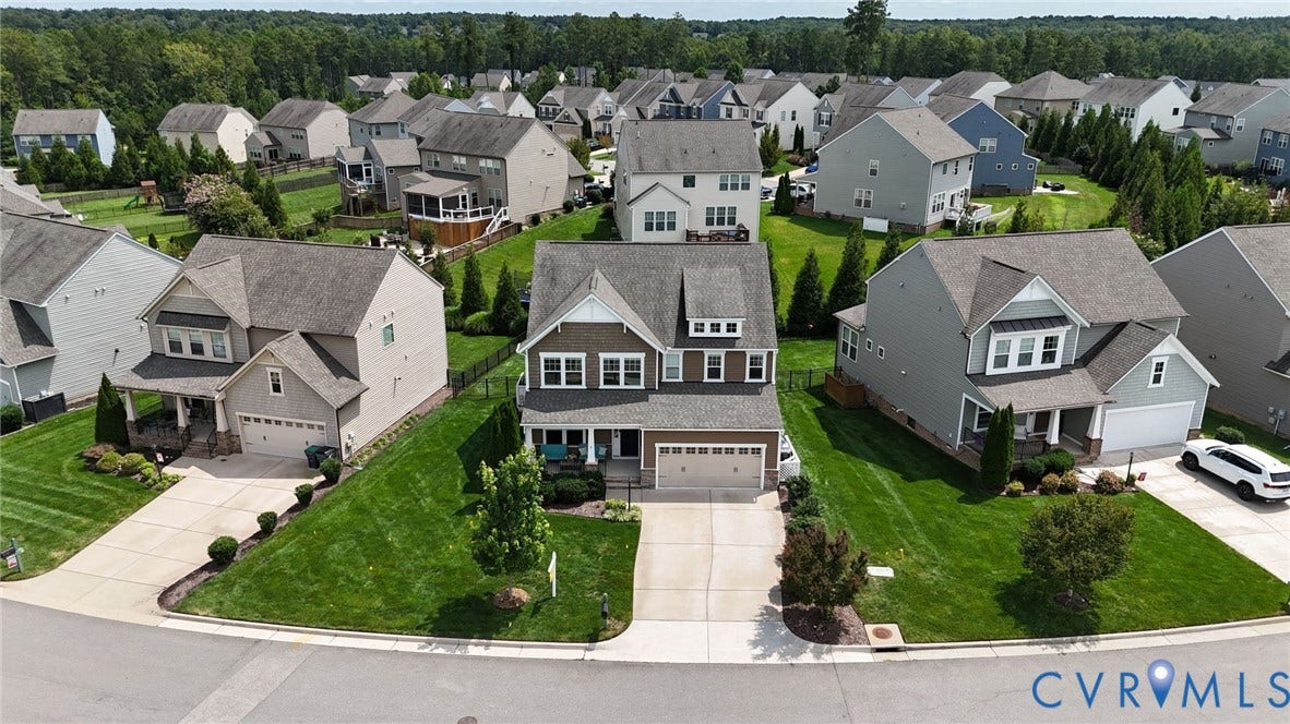 Two-story residential property featuring a masonry and fiber-cement siding facade, a front-facing attached two-car garage, an asphalt shingle roof, and a paved concrete driveway