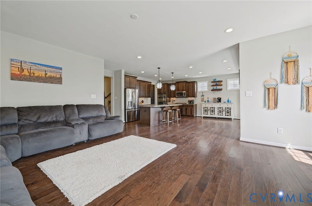 Open-concept interior featuring wood-finish flooring, recessed lighting, and a kitchen island with pendant lighting